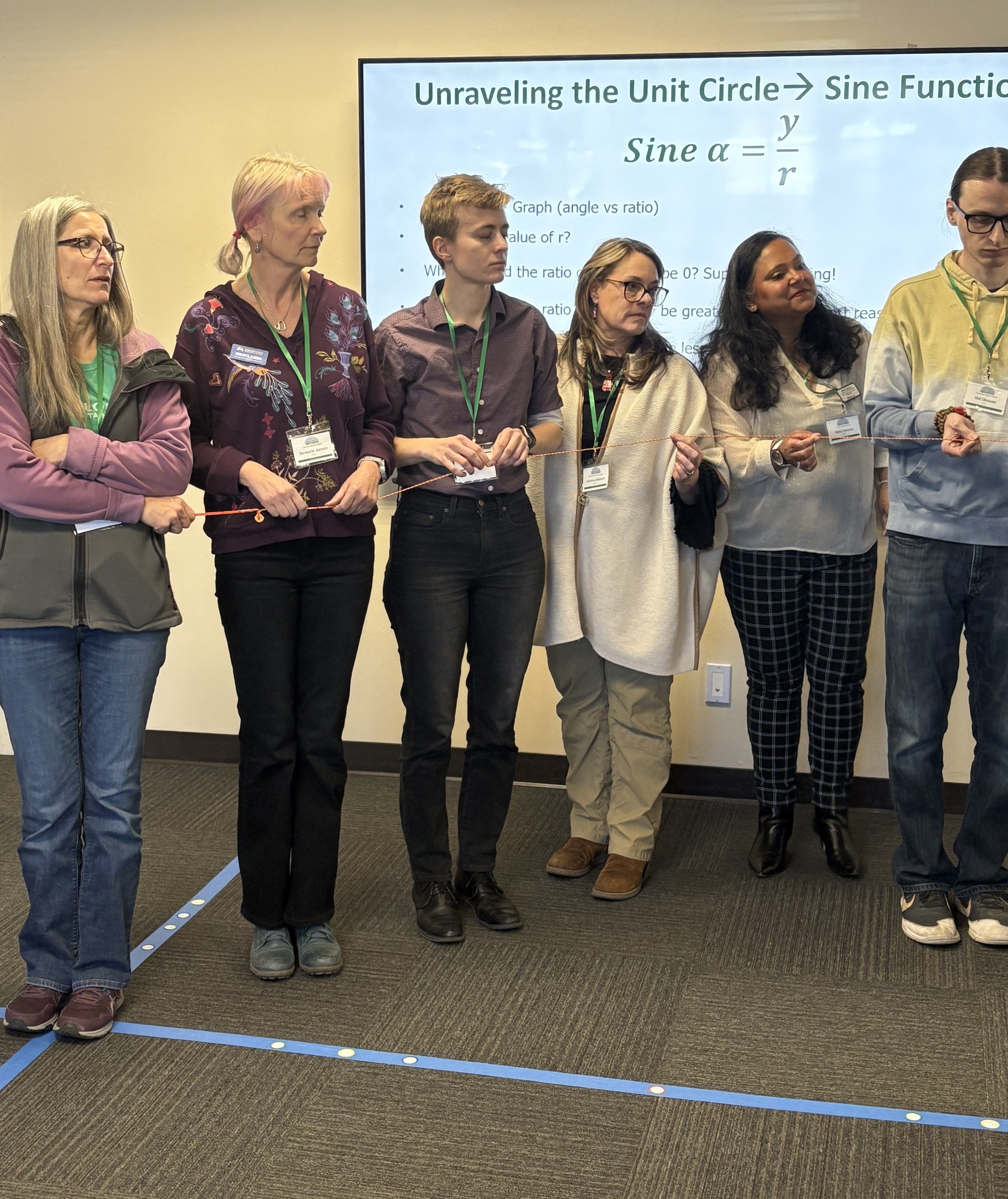 Photo of math educators trying to make a perfect sine curve with string.